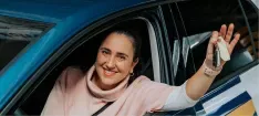 Vrouw met sleutels in haar hand in een VAB rijlesauto