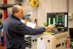 een medewerker van Training & Consult wijst aan wat een diagnosetoestel heeft vastgesteld