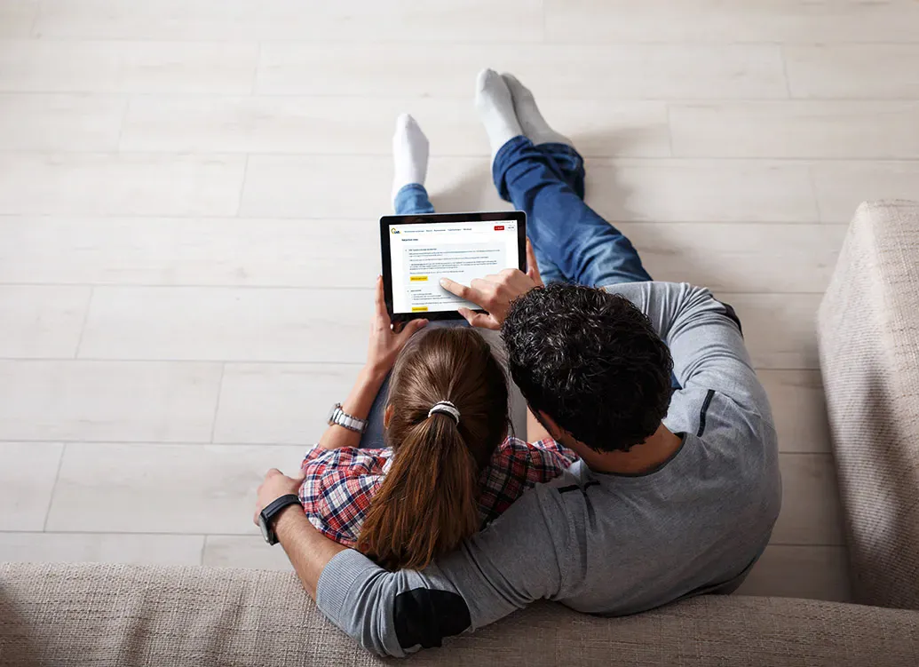man en vrouw zitten op de grond en kiezen een VAB-contract op een tablet