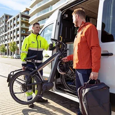 vab-wegenwachter laadt een elektrische fiets van een man uit een pechverhelpingsvoertuig na herstel