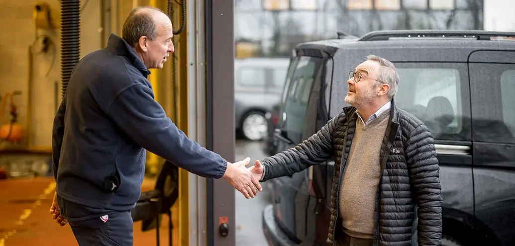 een medewerker van Training & Consult schudt de hand van een tevreden klant