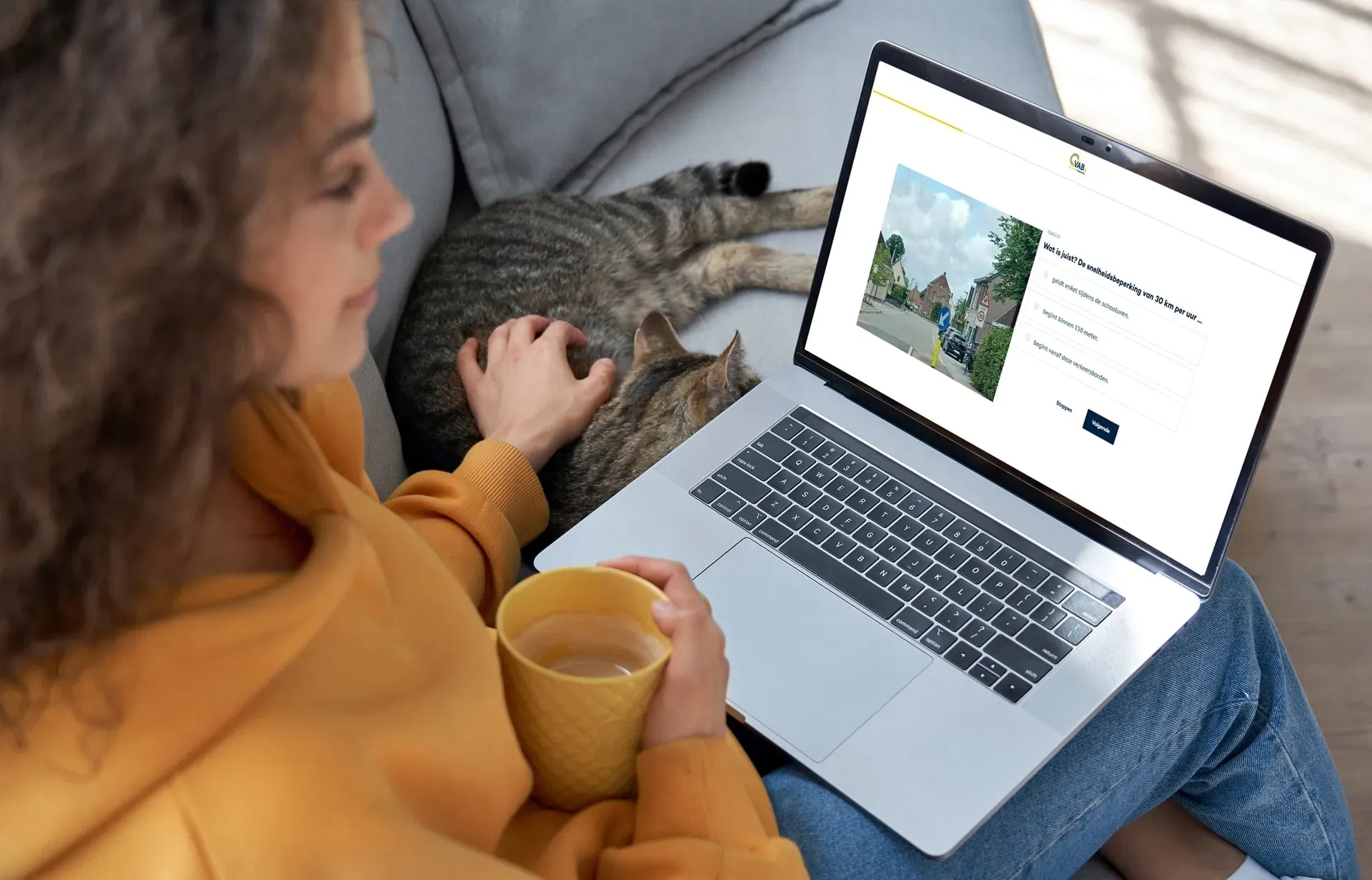 vrouw met kat kijkt naar laptop en doet het vab proefexamen